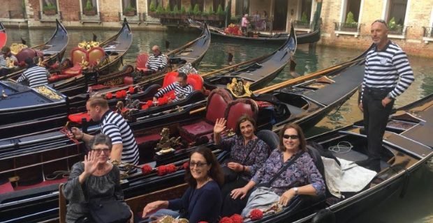 Happy smiling traveler women on gondola ride along the Grand Canal in Venice, Italy