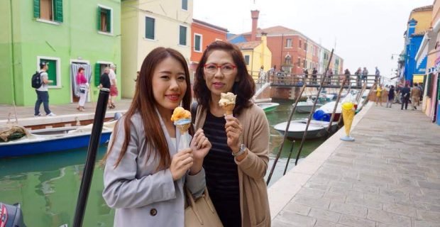 Happy mother-daughter family clients enjoying gelato in Burano, Venice, Italy