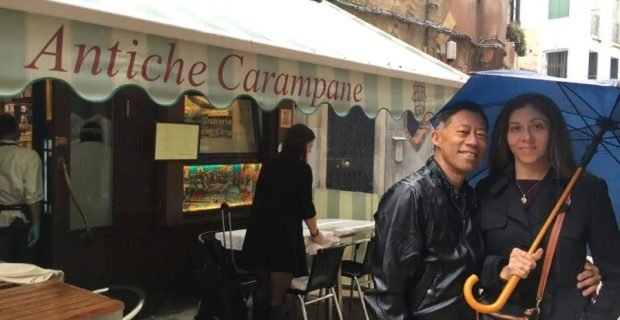 Happy couple of clients having fun in front of Antiche Carampane traditional restaurant in Venice, Italy