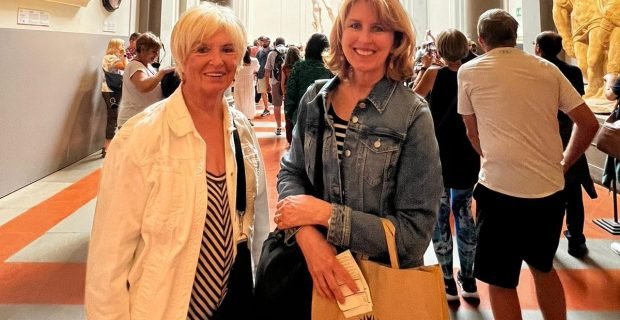 happy mother-daughter client at the Accademia Gallery Museum in Florence, Italy admiring Michelangelo's David